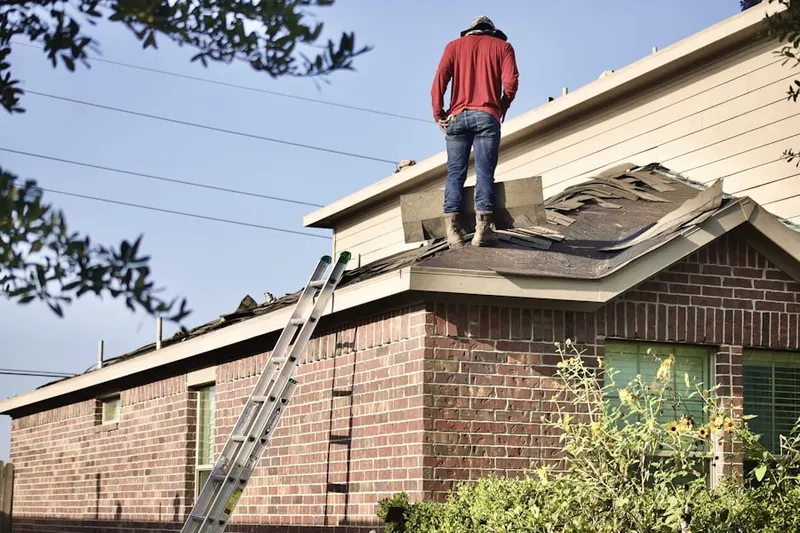 Professional roofer working on a residential roof in Heafer